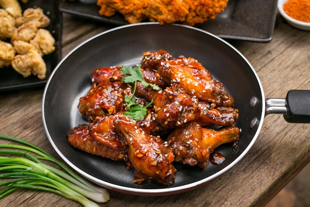 Korean-style fried chicken wings tossed in sticky red sauce with sesame seeds