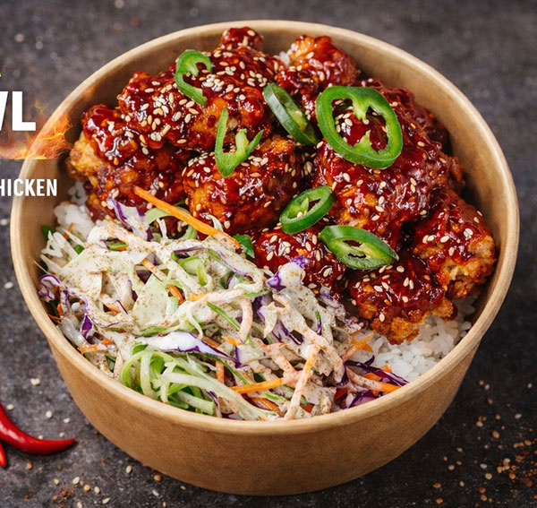 Vibrant rice bowl with crispy chicken bites and fresh asian slaw